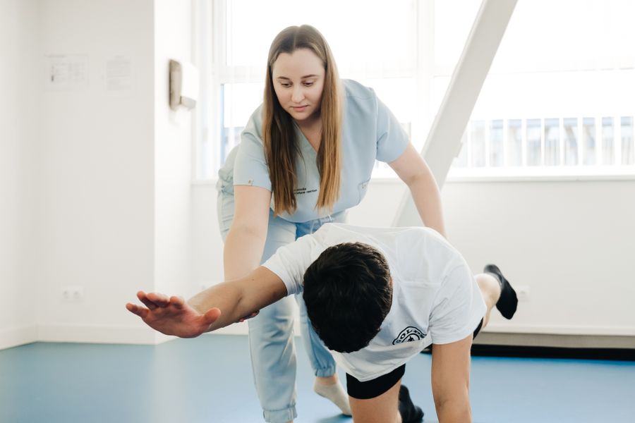 Fisioterapeuta orientando um exercício de alongamento de perna